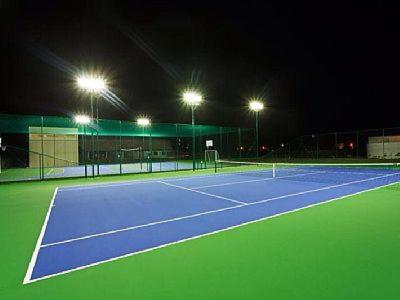 ein Tennisplatz in der Nacht mit eingeschaltetem Licht in der Unterkunft Carneiros Beach Resort apto 208A in Praia dos Carneiros