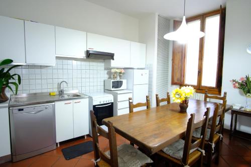 a kitchen and dining room with a wooden table at VILLA IL SORRISO in Bivigliano