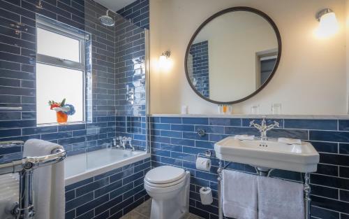 a bathroom with a toilet, sink and mirror at The Hardiman (formerly Hotel Meyrick) in Galway