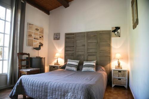 a bedroom with a large bed and two lamps at La Cormorandiere Plage in La Couarde-sur-Mer
