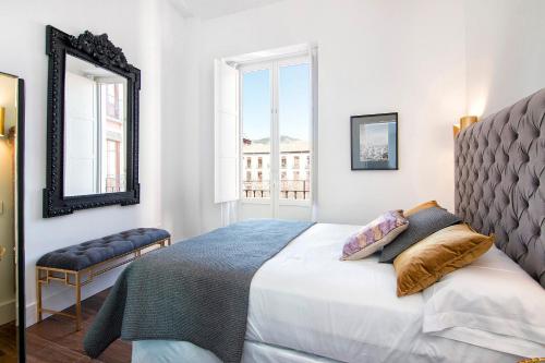 a bedroom with a bed and a mirror at Bib Rambla Luxury Apartments in Granada