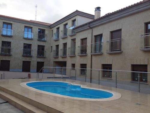 a building with a swimming pool in front of a building at Apartamento Puente Romano Portal 4 1-B in Salamanca