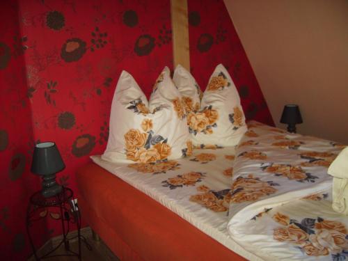 un letto con cuscini e una parete rossa di chez monika a Monswiller