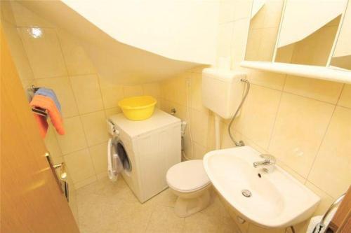 uma pequena casa de banho com WC e lavatório em villa NIKOLA em Brela