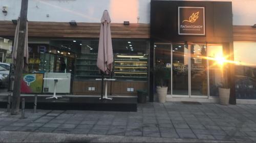 a restaurant with an umbrella in front of a building at MP Cozy Apartment Near the Sea in Paphos City