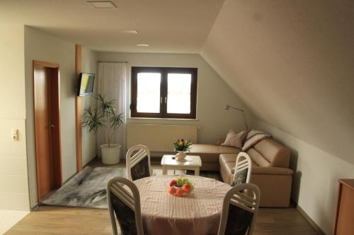 ein Wohnzimmer mit einem Tisch und einem Sofa in der Unterkunft Ferienwohnung Kranichnest in Malschwitz