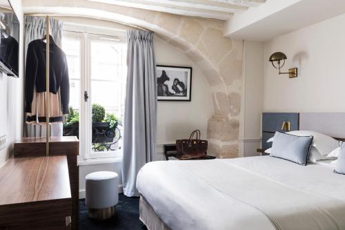 
a bedroom with a large bed and a large window at Hotel Verneuil Saint Germain in Paris
