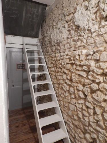 a ladder is leaning against a stone wall at Mimi la Sardine in Saint-Gervais en-Belin
