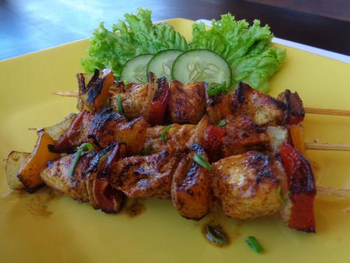 een geel bord met eten met vlees en groenten bij The Cemok's Cottage in Nusa Penida