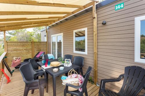 un patio avec une table et des chaises sur une terrasse dans l'établissement Camping Paris-Est, à Champigny-sur-Marne