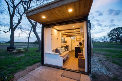 een tiny house in een veld met een woonkamer bij Stillwater House Elegant tiny container home Near Magnolia in Waco