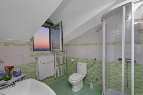 a bathroom with a toilet and a glass shower at Villa Ana in Podgora