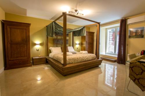 ein Schlafzimmer mit einem Himmelbett in einem Zimmer in der Unterkunft Chiaia 205 in Neapel