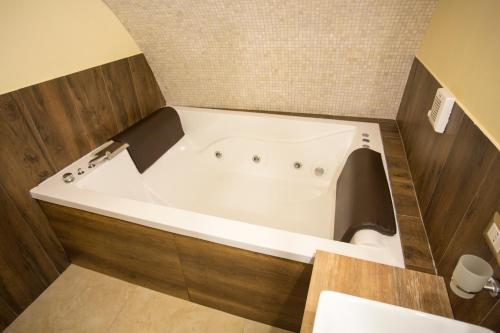 y baño con bañera blanca y pared de azulejos. en Chiaia 205 en Nápoles