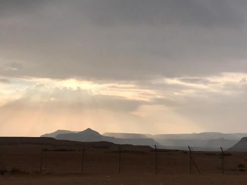 a view of the desert with the sun breaking through the clouds at Nof Beresheet in Midreshet Ben Gurion