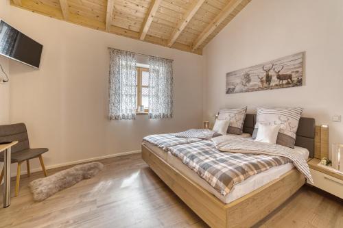 a bedroom with a bed and a desk and a window at Pension und Ferienchalets Zum Lebzelter in Freyung