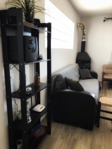a living room with a couch and a tv and a shelf at The Hillhouse near Alexandroupolis (Ground floor) in Alexandroupoli