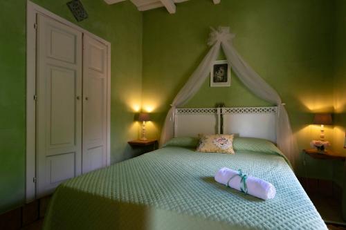 a green bedroom with a bed with a white headboard at Villa Irene in Marsala