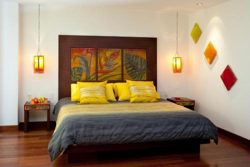 a bedroom with a large bed with yellow pillows at Ikala Quito Boutique Hotel in Quito