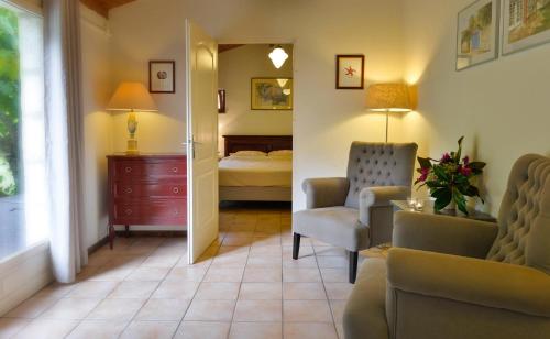 a room with a bedroom with a bed and a chair at Le Prieuré Le Pavillon in Souillac