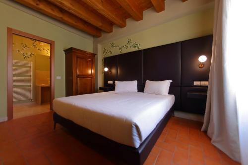 a bedroom with a large white bed in a room at La Boheme Chambres in Lazise