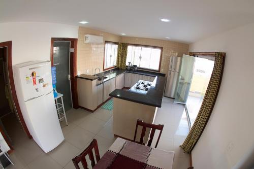 a kitchen with a refrigerator and a table and chairs at Casa Flecha in Canoa Quebrada