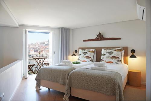 a white bedroom with two beds and a balcony at Porto View by Patio 25 in Vila Nova de Gaia