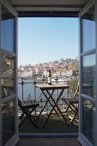 a table and chairs on a balcony with a view of the water at Porto View by Patio 25 in Vila Nova de Gaia