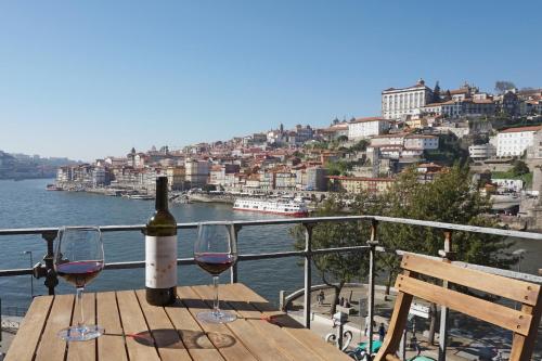 a bottle of wine sitting on top of a wooden pier at Porto View by Patio 25 in Vila Nova de Gaia
