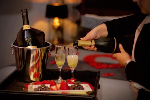 a person pouring champagne into two wine glasses at La Blanca Hotel in Viña del Mar
