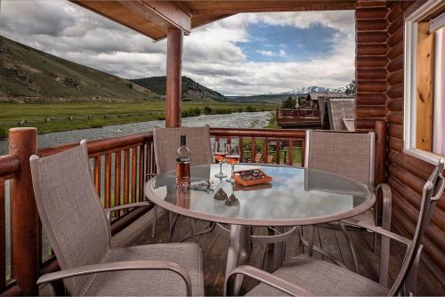 a table and chairs on the balcony of a cabin at Redfish Riverside Inn in Stanley
