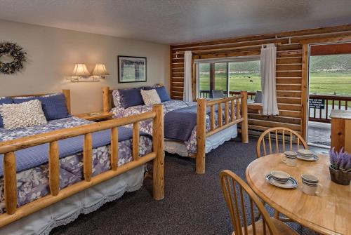 a bedroom with two beds and a table and a dining room at Redfish Riverside Inn in Stanley