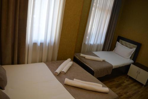 two beds in a small room with white towels on them at Millennium Rabati in Akhaltsikhe