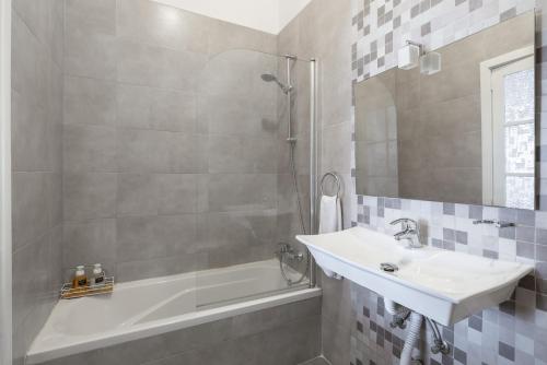 uma casa de banho com um lavatório, uma banheira e um chuveiro em Twilight Holiday Home em Għasri