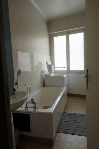 une salle de bain blanche avec une baignoire et un lavabo dans l'établissement Themis by Welcome to Cannes, à Cannes