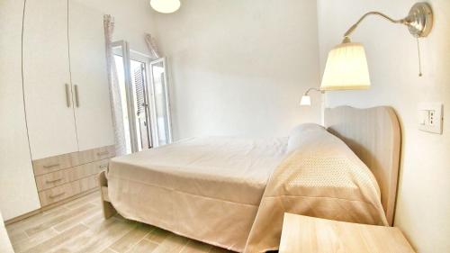 a white bedroom with a bed and a lamp at Tenuta Marga in Agnone