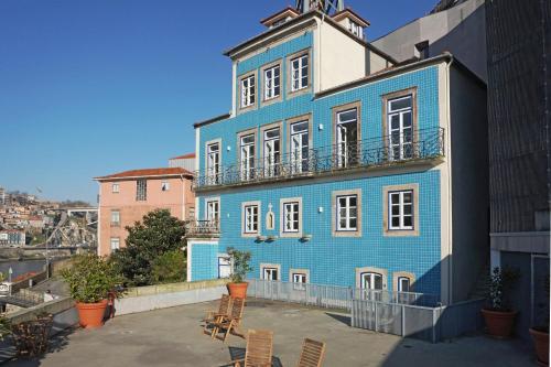 un edificio azul con sillas delante en Porto View by Patio 25 en Vila Nova de Gaia