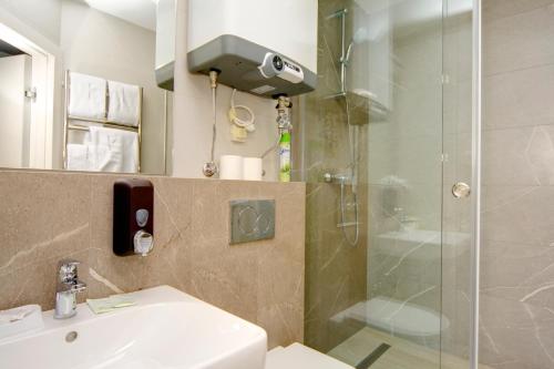 a bathroom with a shower and a sink at Arena Summit Apart Hotel in Kyiv