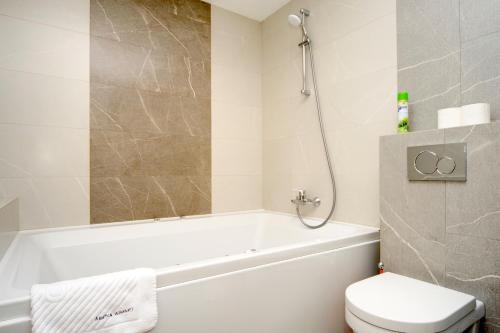 a bathroom with a tub and a toilet and a sink at Arena Summit Apart Hotel in Kyiv
