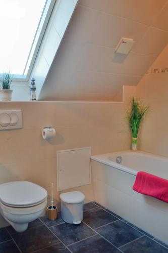 a bathroom with a toilet and a bath tub at Ferienhaus-Bodden in Saal