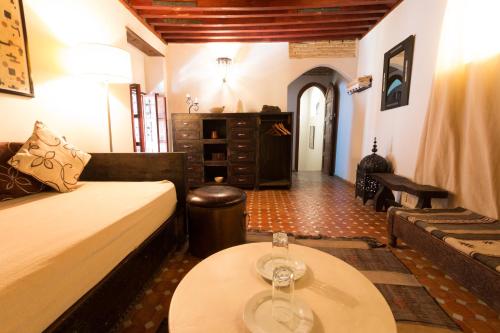 a living room with a bed and a table at Riad El Ma in Meknès