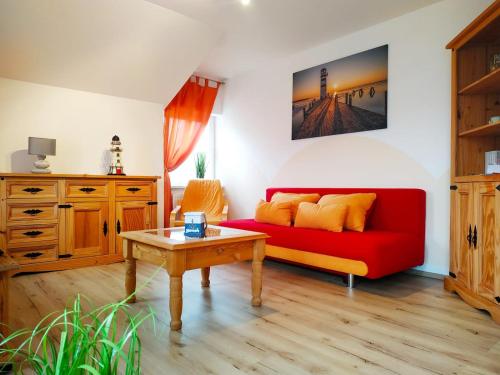 un soggiorno con divano rosso e tavolo di Ostseeperle Usedom a Heringsdorf