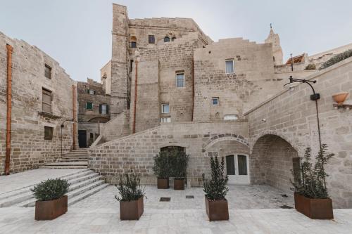 
a large stone building with a clock on it at Cenobio Hotel in Matera
