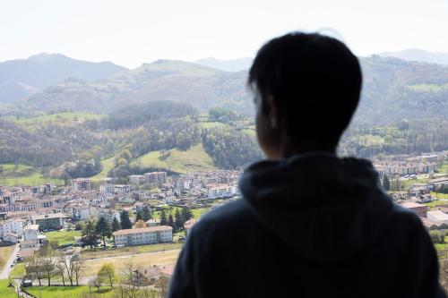 a person looking out of a window at a city at Markulluko Borda Rural Suites in Elizondo