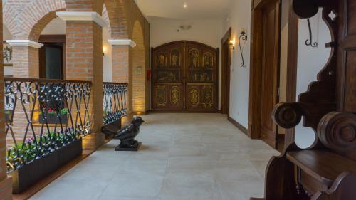 a hallway with a large wooden door and a cat statue at Hotel Otavalo in Otavalo