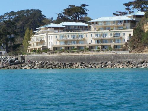 un grand bâtiment blanc sur la rive d'une plage dans l'établissement Cap Morgat, à Crozon