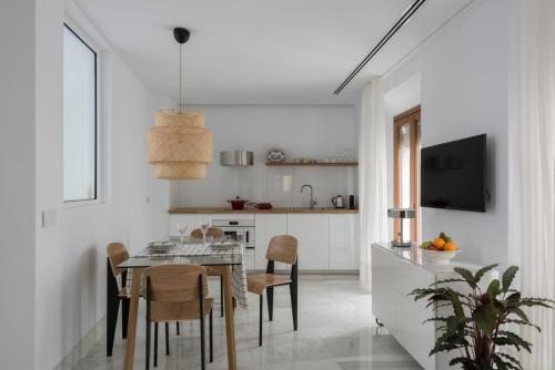 een keuken en eetkamer met een tafel en stoelen bij La casa del Lagar 10 in Sevilla