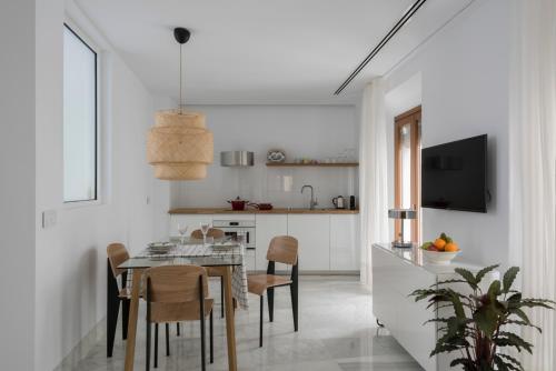 a kitchen and dining room with a table and chairs at La casa del Lagar 10 in Seville