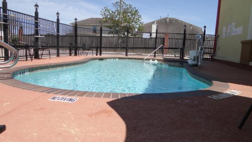 a small swimming pool in a building with a fence at Regency Inn & Suites - Baytown in Baytown