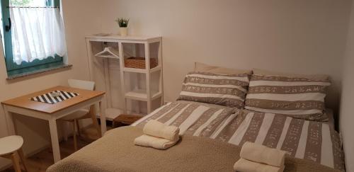 a small bedroom with a bed and a table at Country house in Ankaran